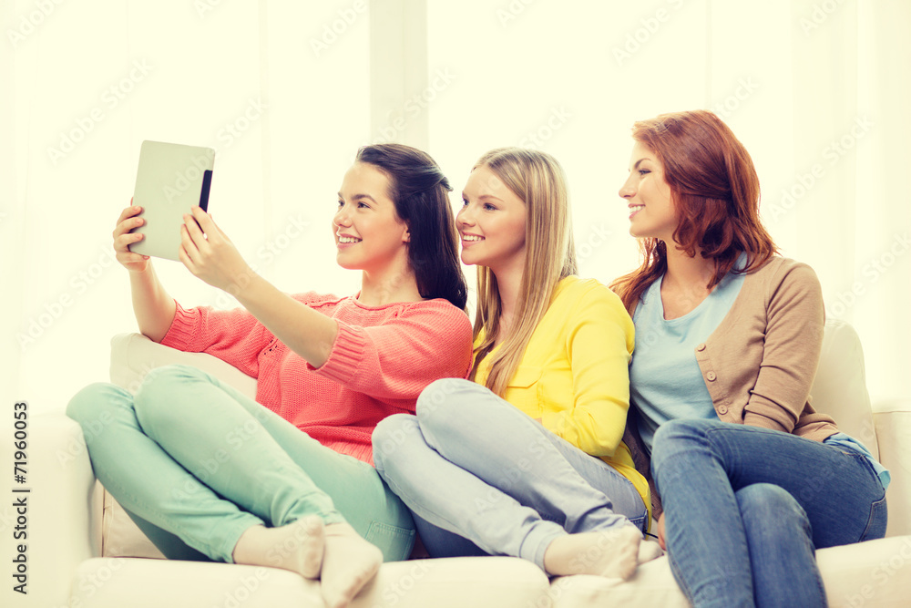 three smiling teenage girls with tablet pc at home three smiling teenage girls with tablet pc at home