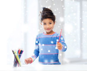 smiling little girl with pencils drawing at home
