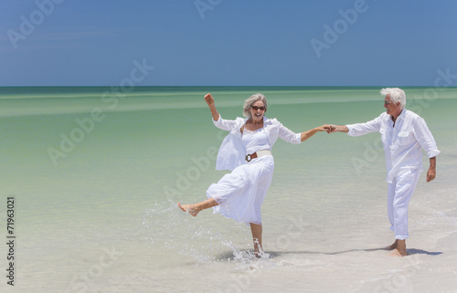 Happy Senior Couple Dancing Holding Hands on A Tropical Beach