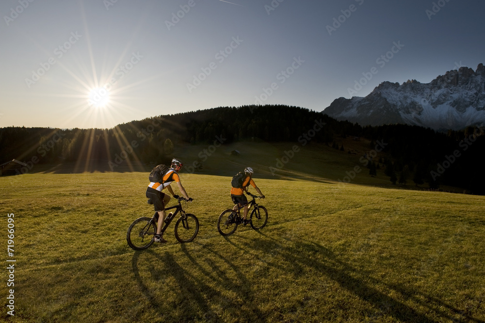 Fototapeta premium two mountainbikers in her shadow - mountainbike