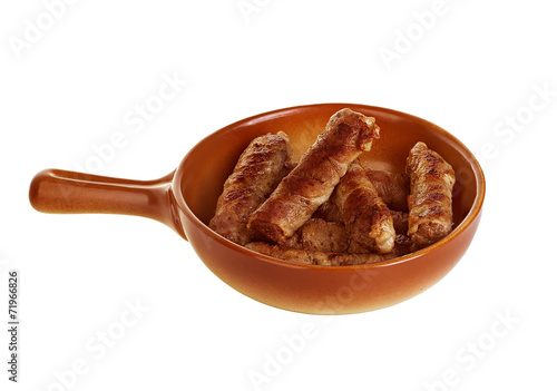 sausages wrapped in bacon in a frying pan photo