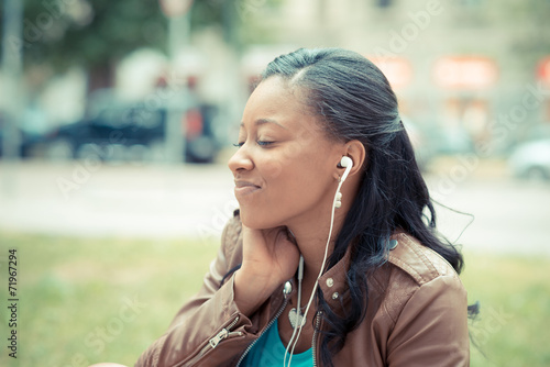 beautiful african young woman listening music earphones
