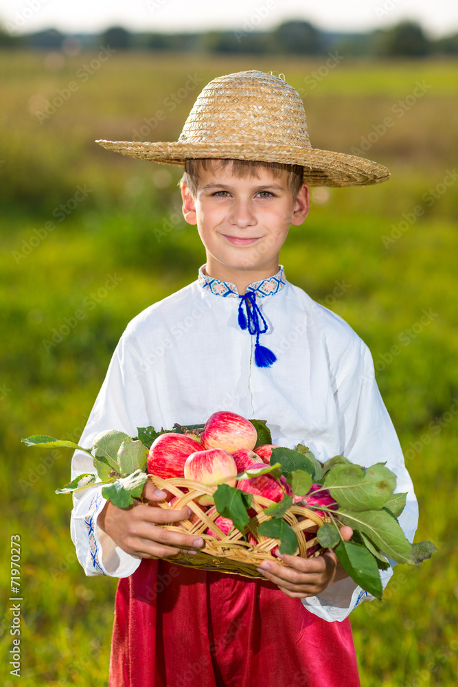 Happy farmer boy hold Organic Apples in Autumn Garden