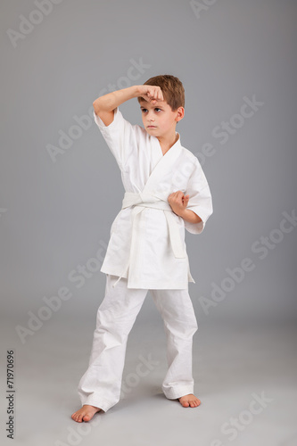 Karate boy in white kimono fighting