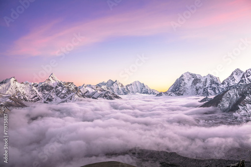 Mountain valley filled with curly clouds at sunrise. Himalayas. photo