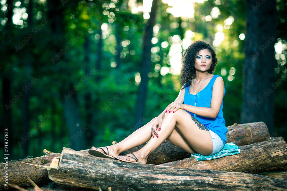 Beautiful Young Woman sitting on log posing Beautiful Young Woman sitting on log posing