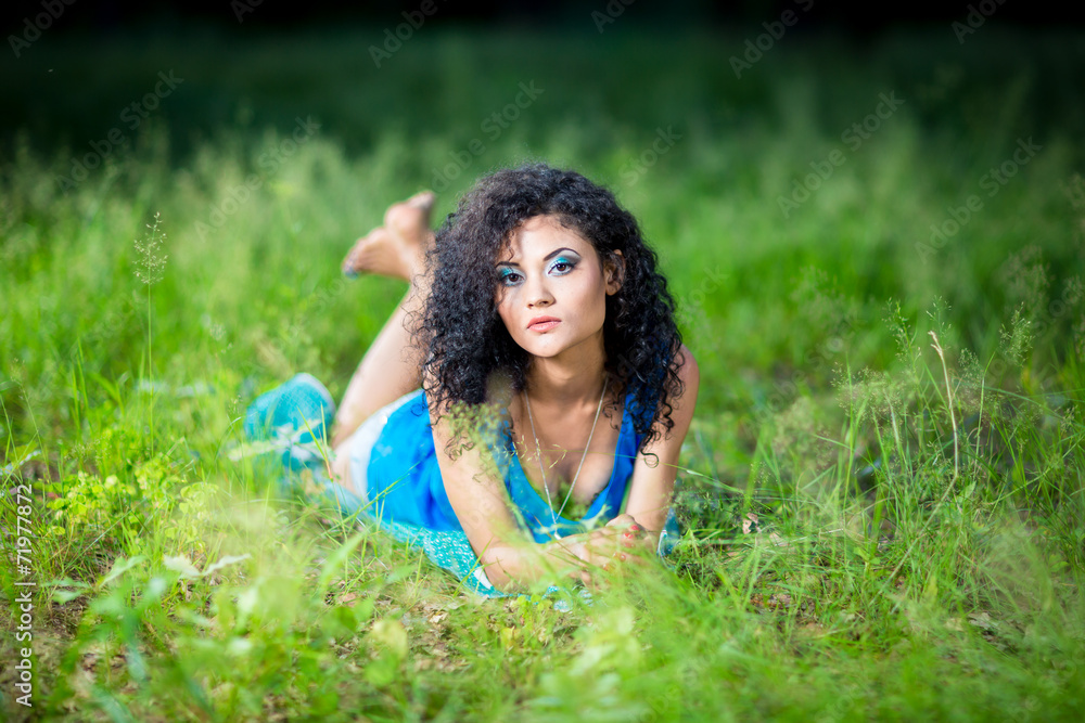 Young relaxing female lying on her stomach in the grass