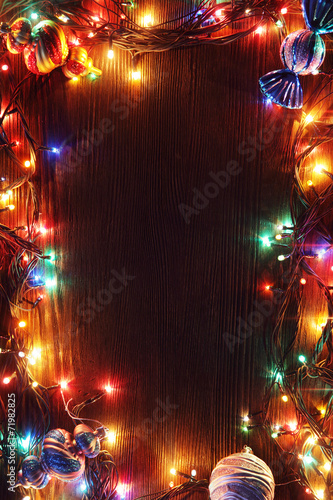 Christmas garlands of lamps on a wooden background.
