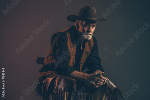 Cigarette smoking old rough western cowboy with gray beard and b photo