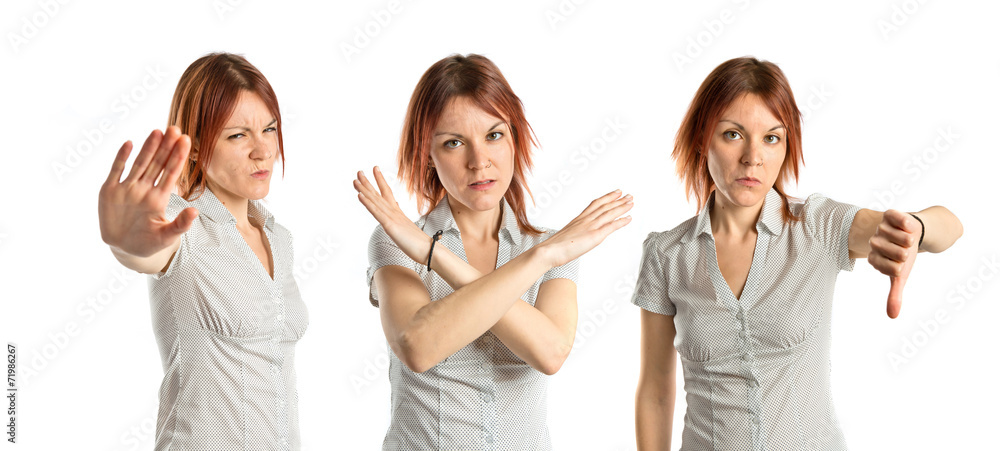Obraz premium Young girl doing a bad signal over white background