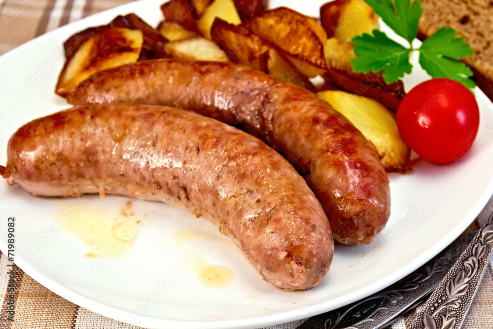 Sausages pork fried with potatoes and tomato on plate Sausages pork fried with potatoes and tomato on plate