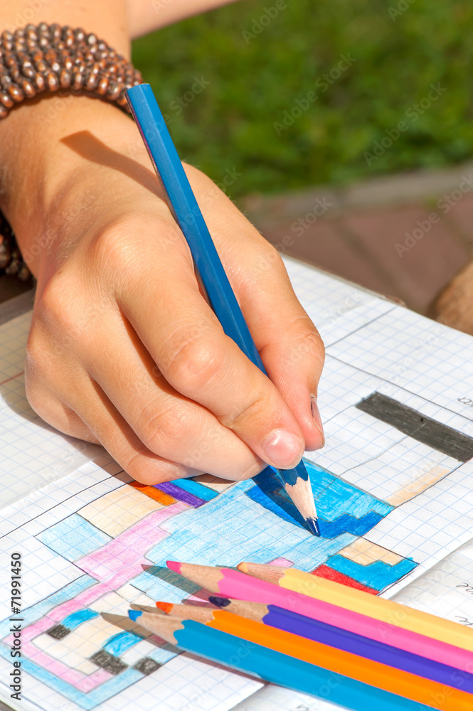 Obraz premium Child hand draws the minecraft picture. Outdoors close-up.