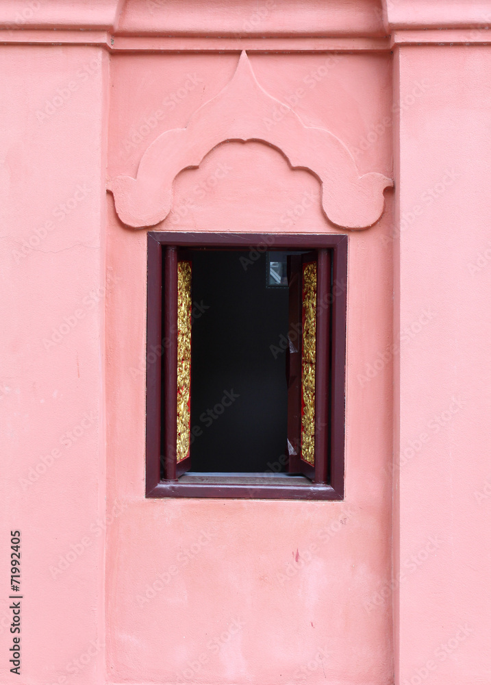 Thai temple window and orange concrete wall.