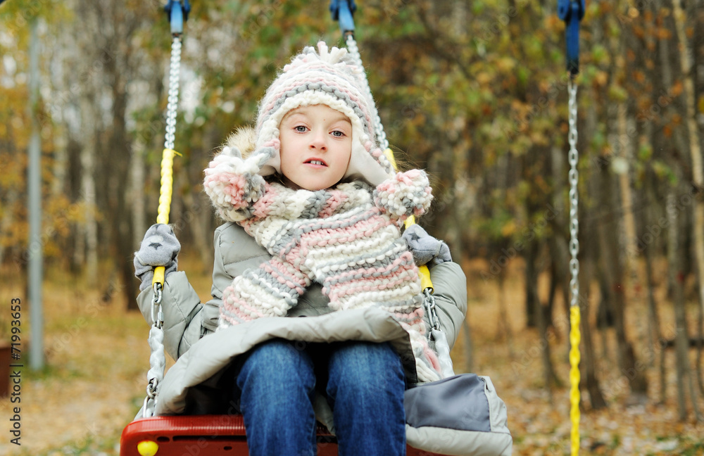 Kid girl on a swing at beautiful winter day Kid girl on a swing at beautiful winter day