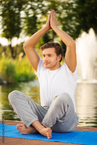 Young man maditating in lotus pose photo