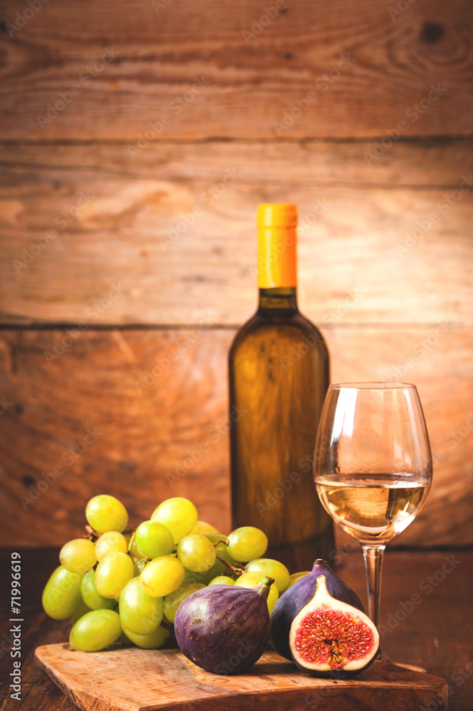 Obraz premium Barrel of white wine with bottle, glass and figs on a rustic tab