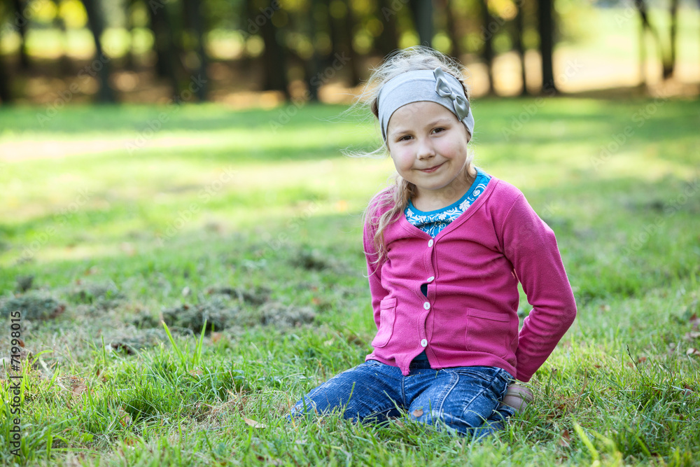 Pretty happy girl portrait, sits on kneels on grass, copyspace Pretty happy girl portrait, sits on kneels on grass, copyspace