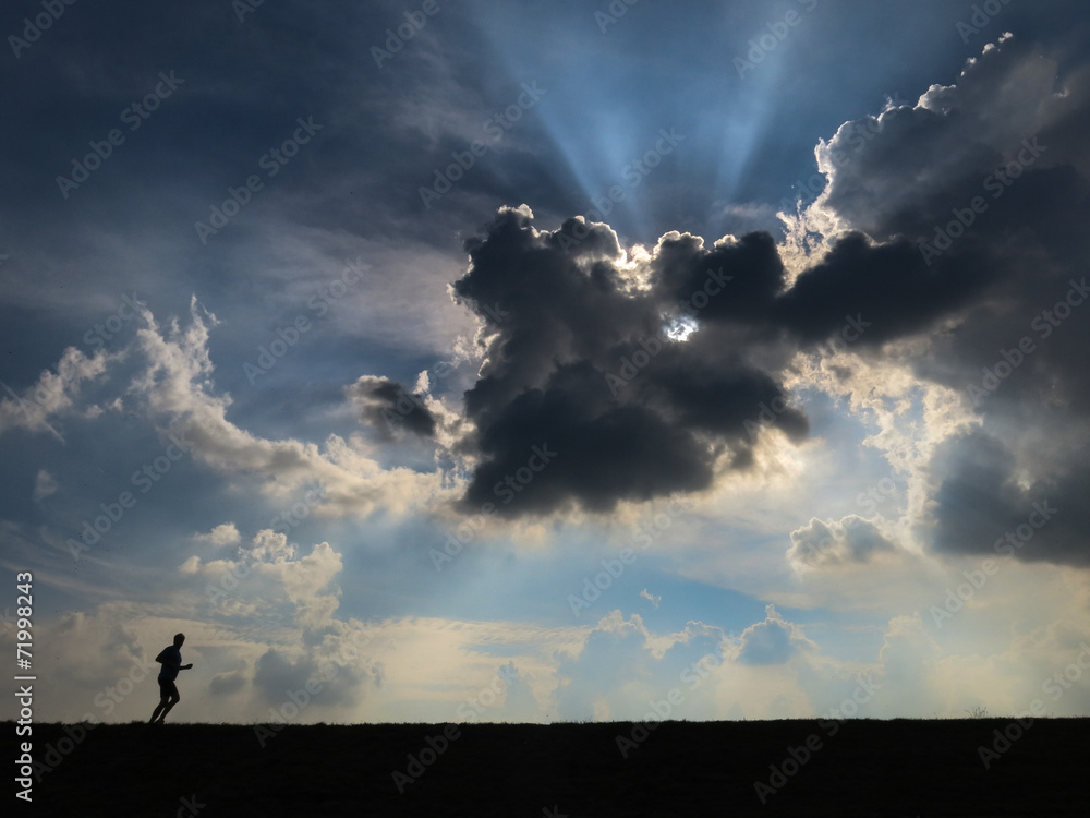 Lonesome jogger Dramatic sky with jogger running - backlighting Lonesome jogger Dramatic sky with jogger running - backlighting