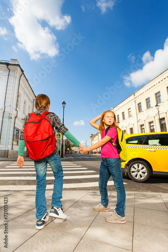 Boy with girl hold hands and stand near road © Sergey Novikov