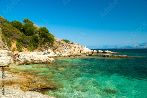 Fototapeta Naklejka Na Ścianę i Meble -  Rocky Kassiopi Beach, Corfu Island, Greece. Sunbeds and umbrella