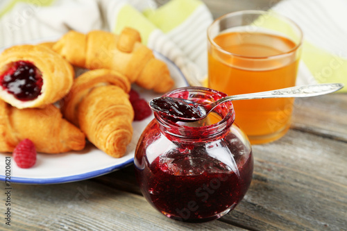 Breakfast with apple juice, jam and fresh croissants