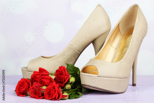 Beautiful woman shoes with flowers on bright background