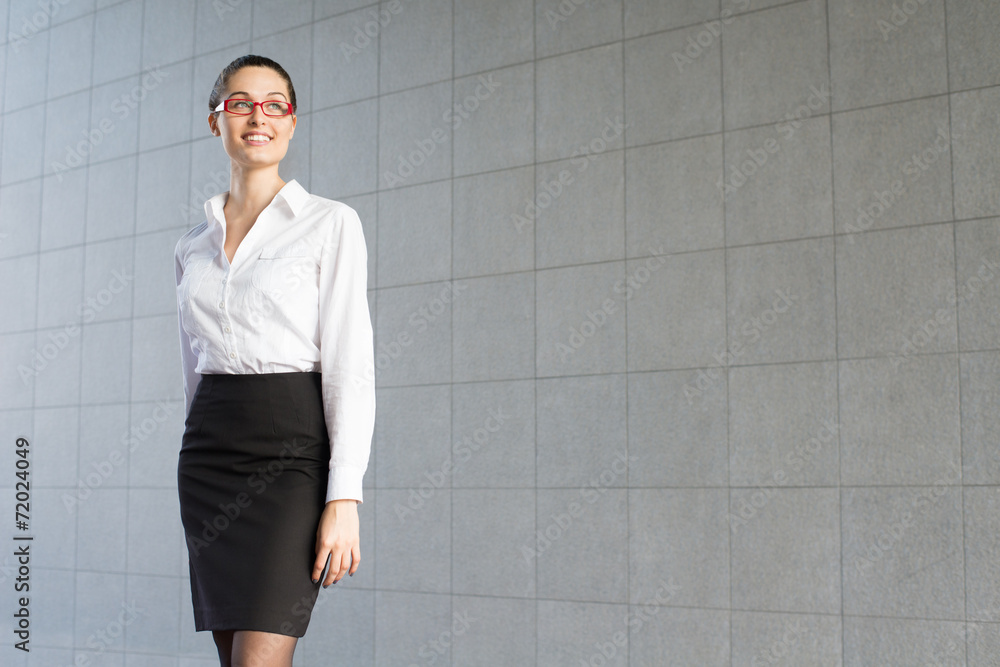 Portrait of a young business woman standing on a gray background Portrait of a young business woman standing on a gray background