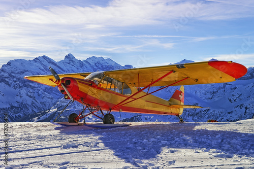 Yellow red airplane at the mountain airfield in swiss alps photo