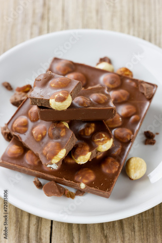 Chopped chocolate with nuts on a white plate