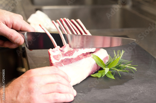 chef hands cutting lamb cutlet photo