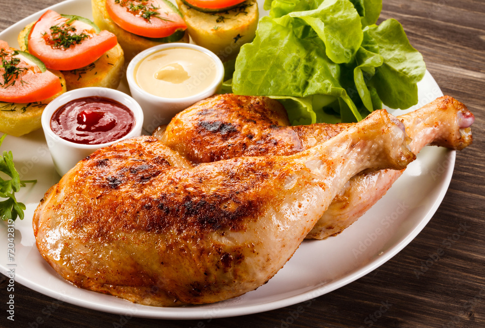 Barbecued chicken legs with French fries and vegetables Barbecued chicken legs with French fries and vegetables