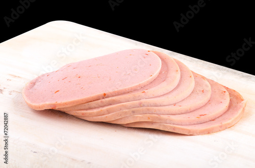 Sliced vegetarian bologna sausage on cutting board