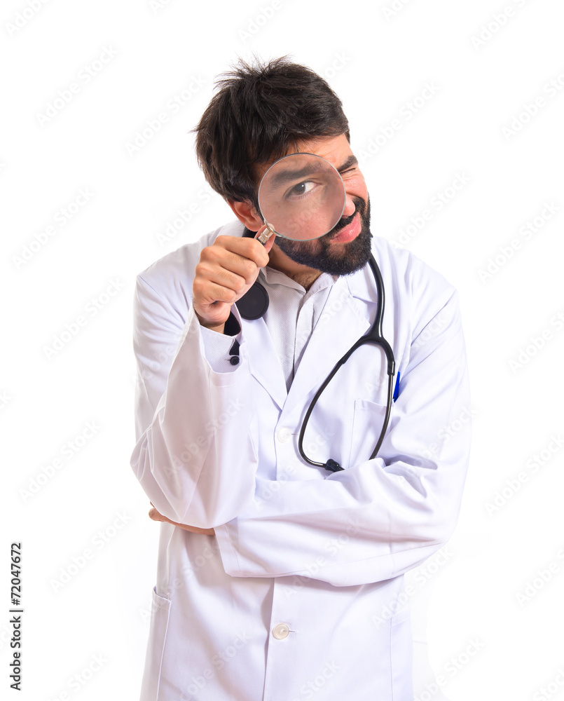 Doctor with magnifying glass over white background Doctor with magnifying glass over white background