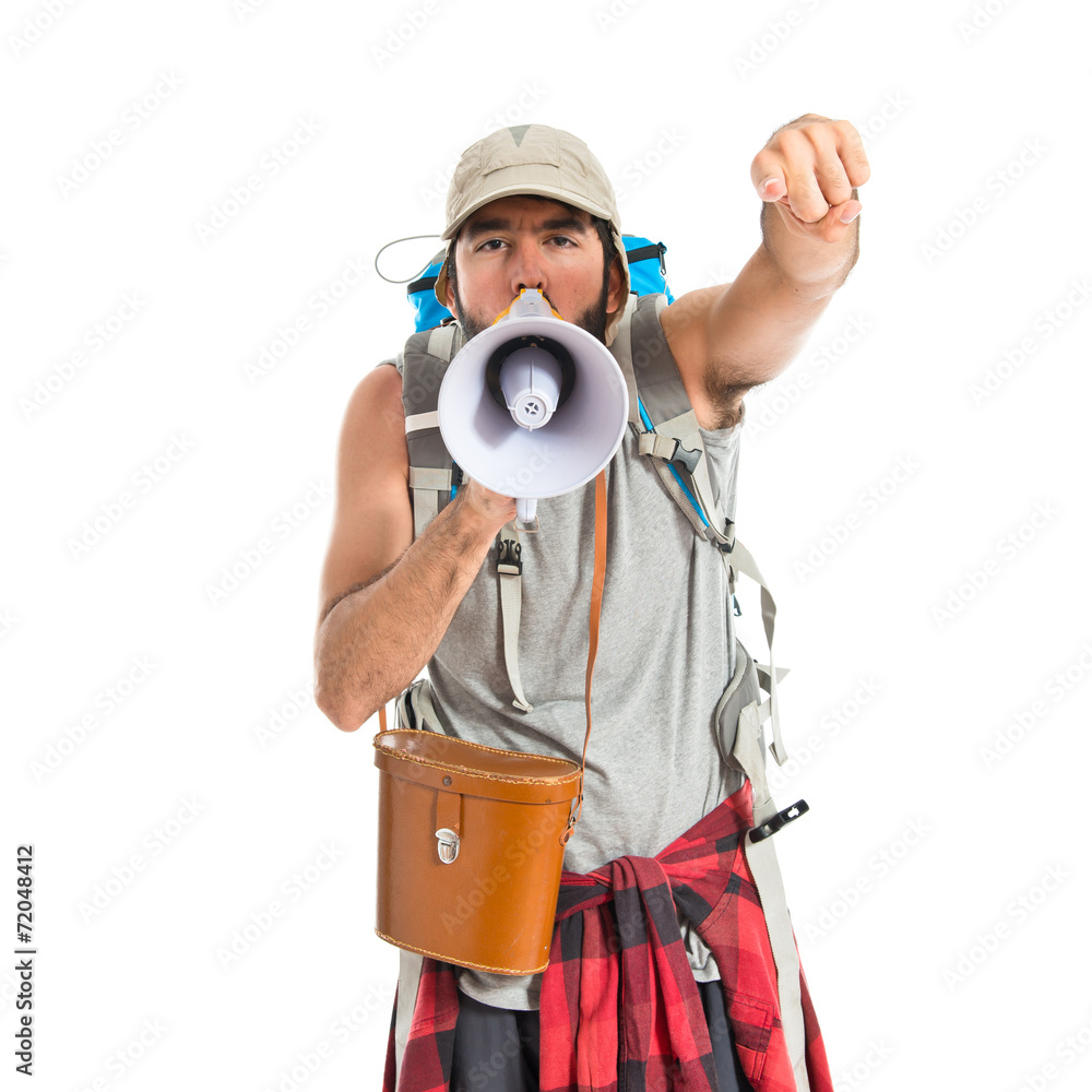 Backpacker shouting by megaphone over white background Backpacker shouting by megaphone over white background