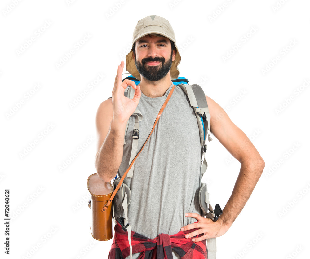 Backpacker making Ok sign over white background Backpacker making Ok sign over white background