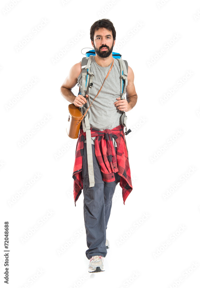 Young backpacker walking over white background Young backpacker walking over white background