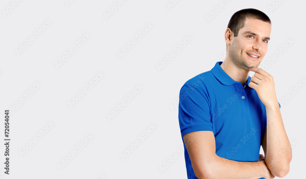 Fototapeta premium Smiling young attractive man, against grey