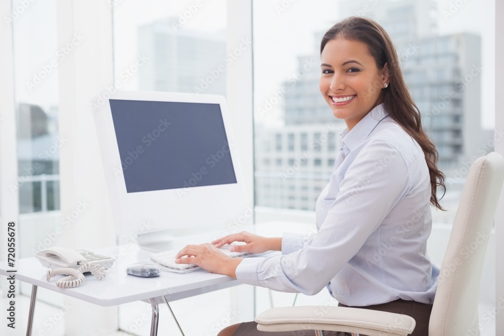 Smiling businesswoman working at her desk Smiling businesswoman working at her desk