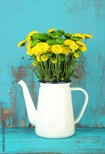 Fototapeta Naklejka Na Ścianę i Meble -  Yellow and green flowers in decorative teapot