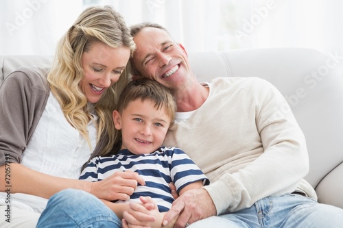 Happy parent tickling her cute son on the couch
