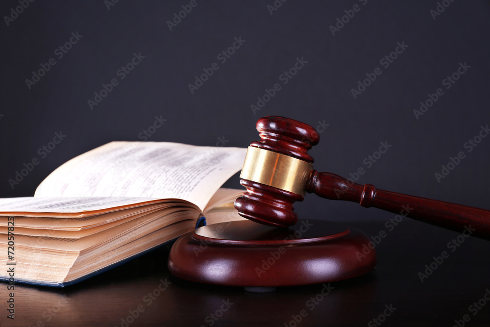 Judge's gavel and open book on dark grey background Judge's gavel and open book on dark grey background