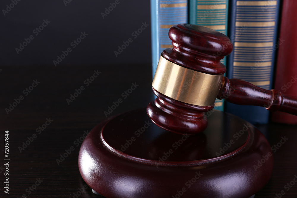 Judge's gavel and books on dark grey background Judge's gavel and books on dark grey background