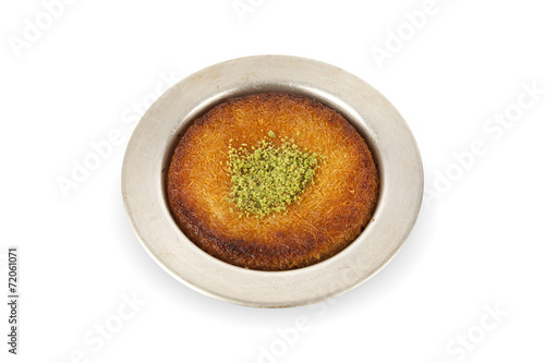 Turkish dessert kunefe with pistachio powder white background