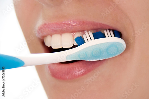 Pulizia di denti con spazzolino photo