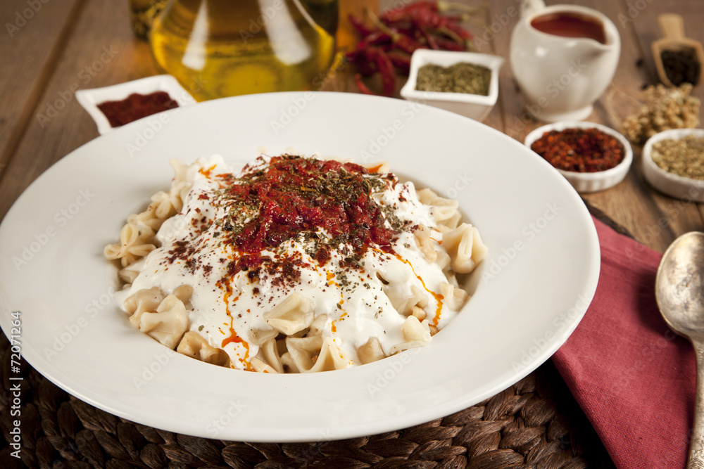 Turkish Manti manlama on plate with tomatoes sauce, yogurt Turkish Manti manlama on plate with tomatoes sauce, yogurt