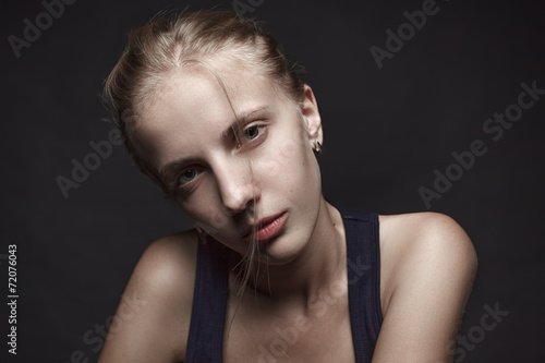 Face portrait of young blond woman without make-up.Black backgro