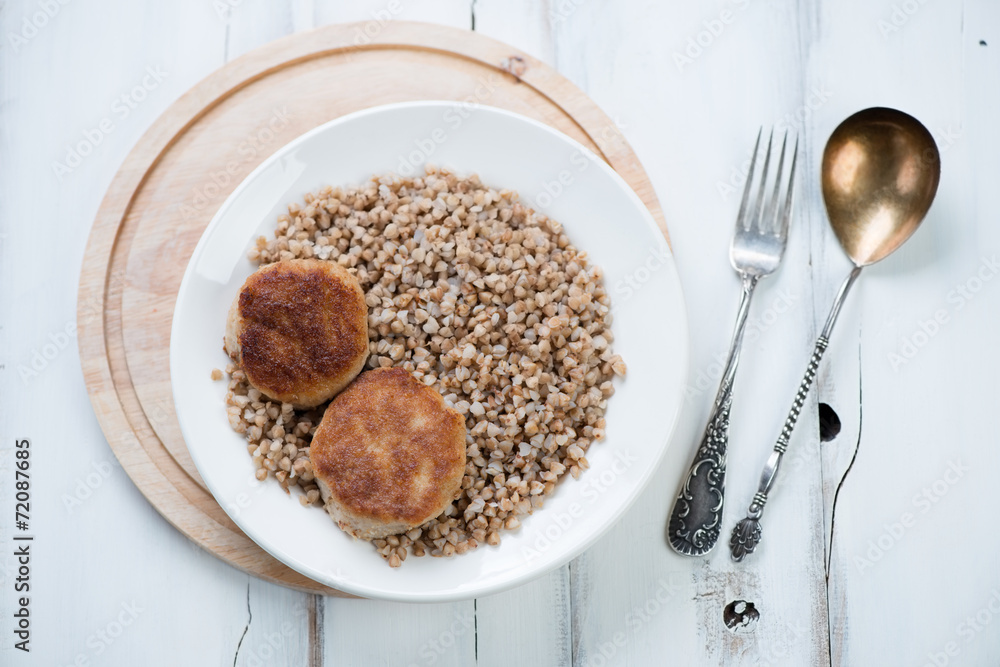 Boiled buckwheat with cutlets, horizontal shot, above view Boiled buckwheat with cutlets, horizontal shot, above view