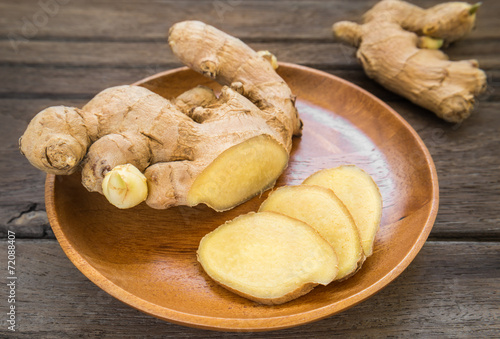 Ginger root sliced on wooden plate