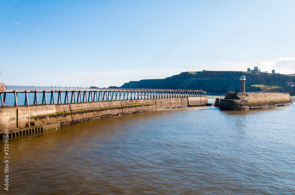Scenic view of Whitby Pier in sunny day in North Yorkshire, UK.