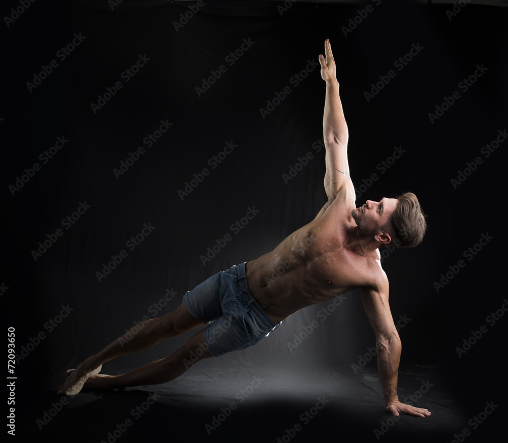Young Sexy Shirtless Man Stretching on the Floor